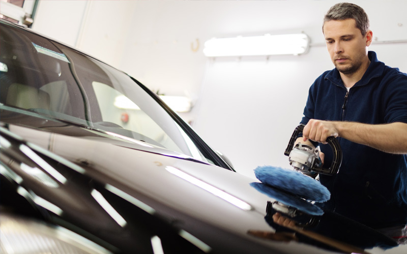 Car wash guy polishing car using a rotary car polisher tool